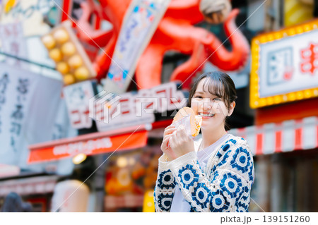 大阪道頓堀で名物のたこせんを食べる女性 大阪道頓堀で名物のたこせんを食べる女性 139151260