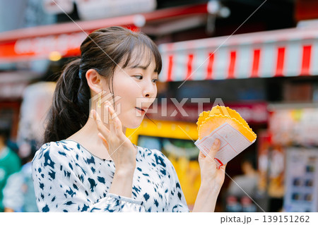 大阪道頓堀で名物のたこせんを食べる女性 大阪道頓堀で名物のたこせんを食べる女性 139151262