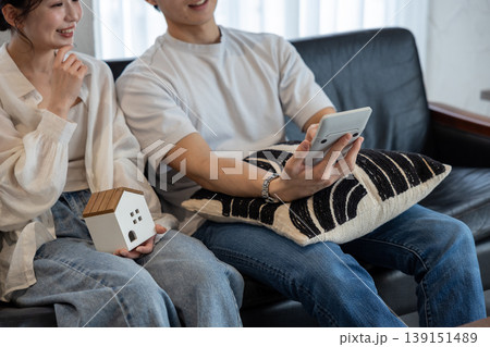 2人でソファに座って家のクラフトと電卓を持って相談している若いカップル 139151489