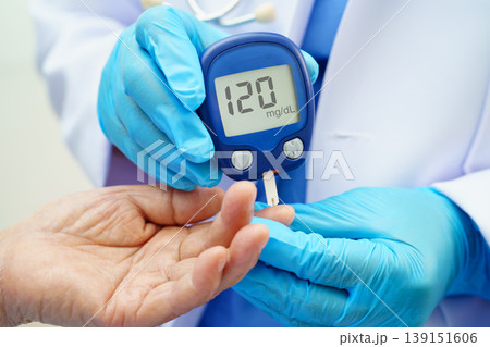 Asian doctor using digital glucose meter for check sample blood sugar level to treatment diabetes. Asian doctor using digital glucose meter for check sample blood sugar level to treatment diabetes. 139151606