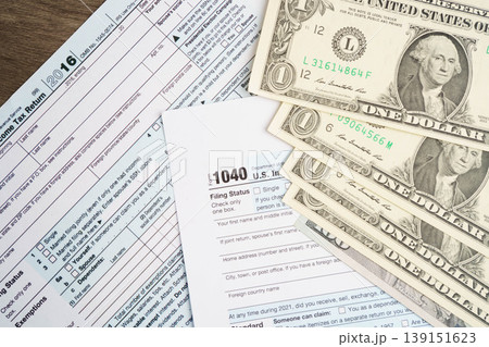 Tax form 1040 U.S. Individual Income Tax Return with dollar banknotes money. Tax form 1040 U.S. Individual Income Tax Return with dollar banknotes money. 139151623