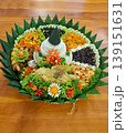 Authentic Indonesian tumpeng rice cone served with traditional side dishes on banana leaves. Popular festive dish for celebrations and cultural ceremonies. 139151631