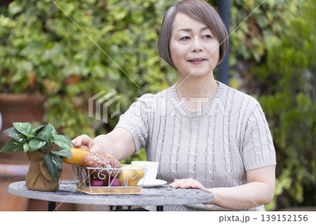 テラスでコーヒーを飲むシニア女性 テラスでコーヒーを飲むシニア女性 139152156