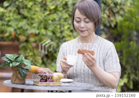 テラスでコーヒーを飲むシニア女性 テラスでコーヒーを飲むシニア女性 139152160