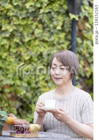 テラスでコーヒーを飲むシニア女性 テラスでコーヒーを飲むシニア女性 139152163