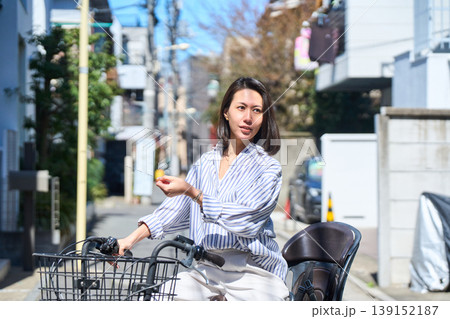 晴れた日に笑顔でママチャリを運転する日本人女性 139152187