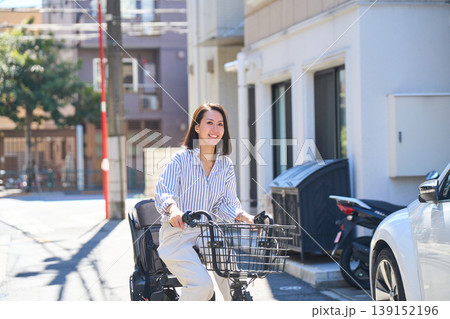 晴れた日に笑顔でママチャリを運転する日本人女性 晴れた日に笑顔でママチャリを運転する日本人女性 139152196