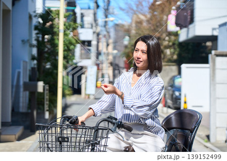晴れた日に笑顔でママチャリを運転する日本人女性 139152499