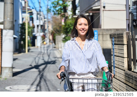 晴れた日に笑顔でママチャリを運転する日本人女性 139152505