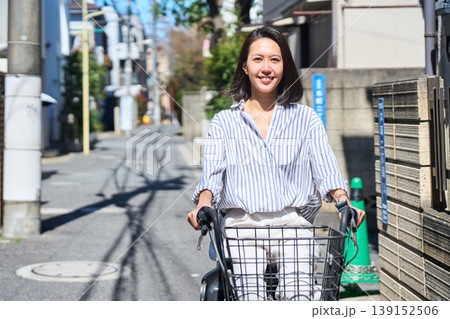 晴れた日に笑顔でママチャリを運転する日本人女性 139152506