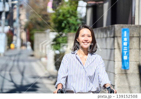 晴れた日に笑顔でママチャリを運転する日本人女性 晴れた日に笑顔でママチャリを運転する日本人女性 139152508