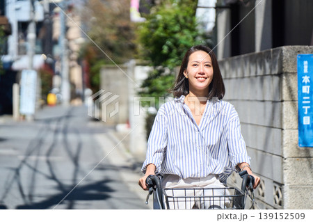晴れた日に笑顔でママチャリを運転する日本人女性 139152509