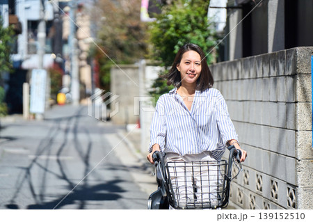 晴れた日に笑顔でママチャリを運転する日本人女性 139152510