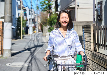 晴れた日に笑顔でママチャリを運転する日本人女性 139152511