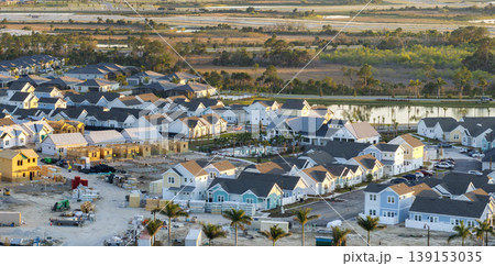 Wooden frames of new cheap American homes under construction. Development of residential housing in the USA Wooden frames of new cheap American homes under construction. Development of residential housing in the USA 139153035