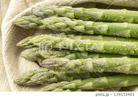 新鮮な緑のアスパラガスを並べた水滴輝く春野菜の写真 新鮮な緑のアスパラガスを並べた水滴輝く春野菜の写真 139153401