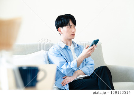 リビングでスマホを使う男性 リビングでスマホを使う男性 139153514