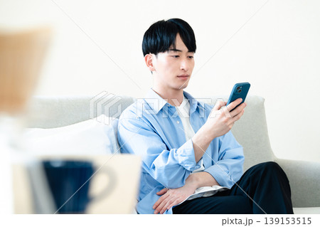 リビングでスマホを使う男性 139153515