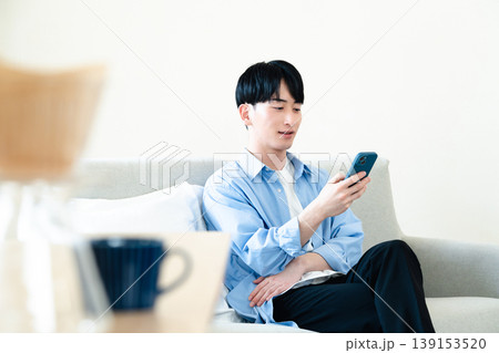 リビングでスマホを使う男性 139153520