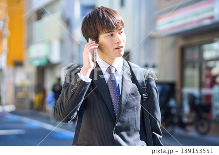 外回りの営業中に街中で電話対応をする若い日本人ビジネスマン 139153551