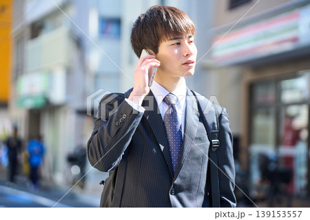 外回りの営業中に街中で電話対応をする若い日本人ビジネスマン 139153557