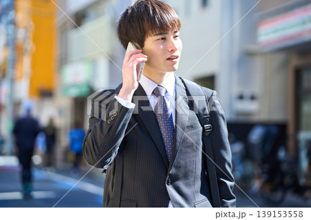 外回りの営業中に街中で電話対応をする若い日本人ビジネスマン 139153558