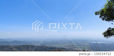 view of the land from the top of the hill with a cloudy blue sky 139154712
