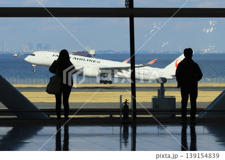 羽田空港第2ターミナル国際線エリアから滑走路を眺める利用客 滑走路を眺める利用客のシルエット 羽田空港第2ターミナル国際線エリアから滑走路を眺める利用客 滑走路を眺める利用客のシルエット 139154839