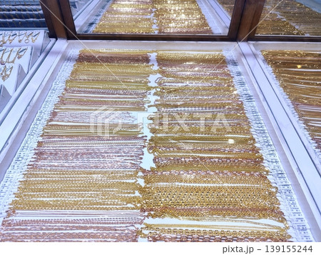 Photo of gold jewelry, necklaces, rings, bracelets in a glass display case Photo of gold jewelry, necklaces, rings, bracelets in a glass display case 139155244