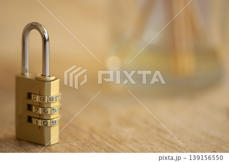Brass combination padlock on wooden desk with copy space 139156550