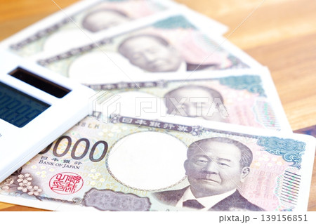 一万円紙幣と電卓 - テーブルの上に置かれた10000円札と電卓 139156851