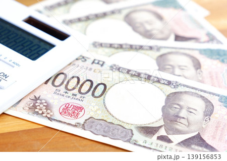 一万円紙幣と電卓 - テーブルの上に置かれた10000円札と電卓 139156853