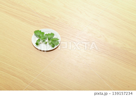 テーブルの上の白い豆皿に置かれたヒイラギ・柊の葉 139157234