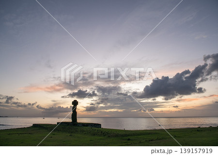 Serene moai statue silhouette on Easter Island Chile facing glowing sunrise Serene moai statue silhouette on Easter Island Chile facing glowing sunrise 139157919