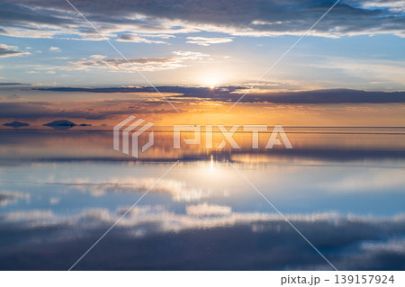 Serene sunset reflection on uyuni salt flat water in bolivia Serene sunset reflection on uyuni salt flat water in bolivia 139157924
