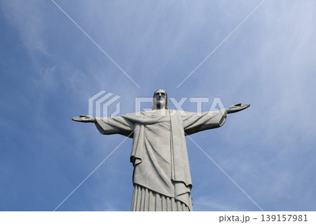 Majestic peaceful redeemer statue standing with welcoming gesture under blue sky in sunny rio de janeiro inspiring deep awe 139157981