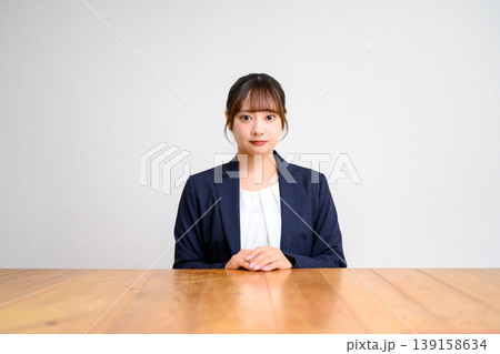 テーブルに座るスーツ姿の女性 139158634