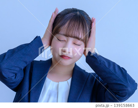耳を塞ぐスーツ姿の女性 139158663