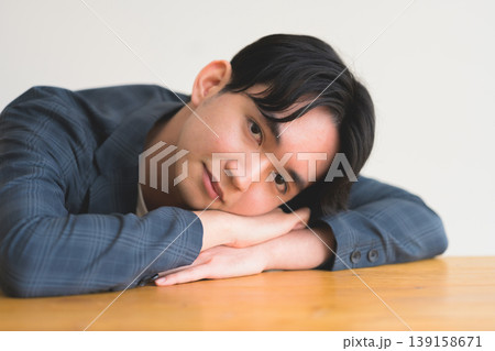 男性がテーブルに顔をうずめる 139158671