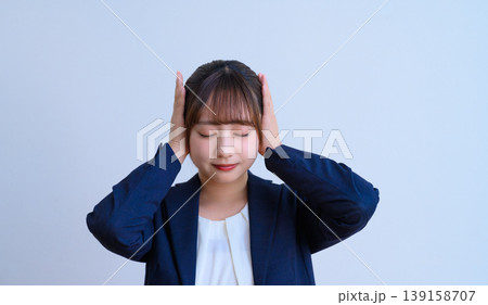 目を閉じて耳を塞ぐ女性 139158707