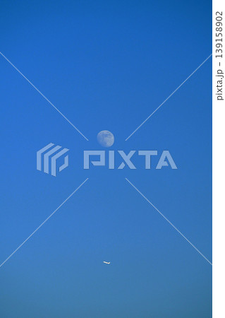 青空に月と飛行機 139158902