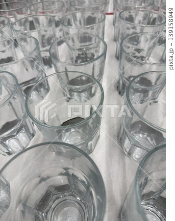 Rows of empty glass cups upside down in rows on table creating abstract pattern background Rows of empty glass cups upside down in rows on table creating abstract pattern background 139158949