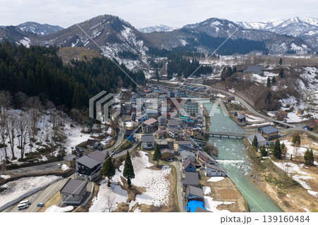 残雪の山々に囲まれた山形県肘折温泉の温泉街を4月に空撮した写真 139160484