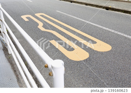 30km/h制限の道路。黄色いペイント表示と白いガードレール。安全標識 139160623