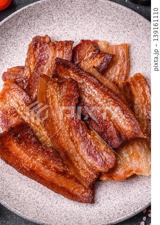 Fried fresh bacon slices with layers of meat or prosciutto prepared for breakfast. Fried bacon 139161110