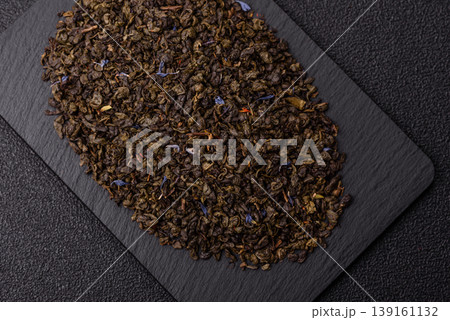 Granules of dried organic Chinese green tea with herbal additives. Dry green tea 139161132