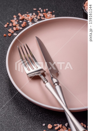 An empty ceramic round plate, kitchen utensils for a dinner table. An empty plate An empty ceramic round plate, kitchen utensils for a dinner table. An empty plate 139161144