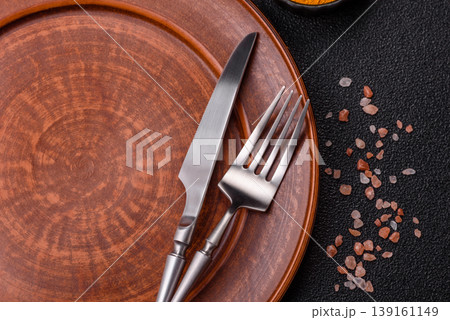 An empty ceramic round plate, kitchen utensils for a dinner table. An empty plate 139161149