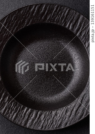 An empty ceramic round plate, kitchen utensils for a dinner table. An empty plate An empty ceramic round plate, kitchen utensils for a dinner table. An empty plate 139161151