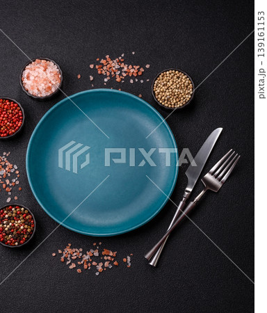 An empty ceramic round plate, kitchen utensils for a dinner table. An empty plate 139161153